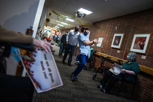 Nursing home residents hold signs as staff members walk by during a Thanksgiving celebration at the Hebrew Home at Riverdale, in New York.